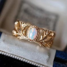 Meticulously crafted, this statement ring features a genuine natural Opal set in intricate detailing. The 14K gold-plated sterling silver enhances the timeless elegance of the design. Elevate your style with this exquisite ring, where the captivating beauty of natural Opal meets the refined craftsmanship of gold-plated sterling silver. This Ring is adjustable. Product Details & Spec Ring Width: 6.5 mm Weight: 2.3g Gold Open Ring Opal Fine Jewelry, Heirloom Gold Opal Promise Ring, Elegant Gold Opal Open Ring, Ornate 14k Gold Promise Ring, Ornate Gold Filigree Ring With Gemstone, Gold Filigree Ring With Gemstone, Gold Filigree Ring With Gemstone In Fine Jewelry Style, Light Gold Color, Synthetic Opal