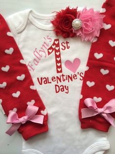 a red and white onesuit with pink bows on it's chest is decorated with hearts