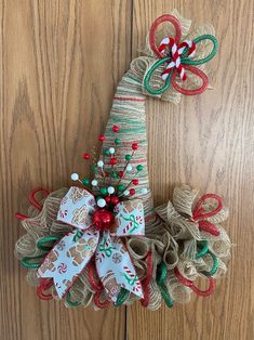 two christmas wreaths made out of burlocks and ribbons on a wooden surface