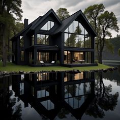 a large black house sitting on top of a lake