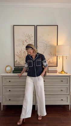 a woman standing in front of a dresser