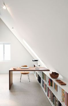 an attic office with bookshelves and a desk