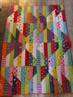 a multicolored patchwork quilt on the floor