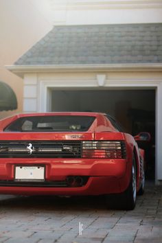 a red sports car parked in front of a house