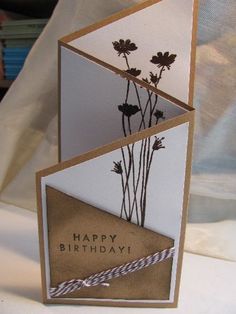 a birthday card with some flowers in the middle and an envelope on top that says happy birthday