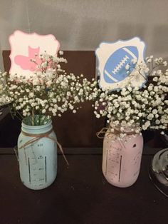 two mason jars with baby's breath flowers in them are sitting on a table