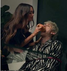 a woman is eating an apple while another woman looks on