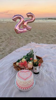 a table with a cake, wine bottle and balloon in the shape of two letters