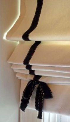 a stack of folded white sheets with black ribbon