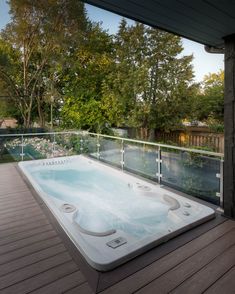 a large hot tub sitting on top of a wooden deck