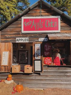 an apple cider is on display in front of a building with wooden siding and windows