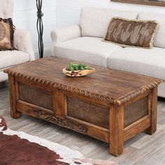 a living room with two couches and a coffee table in front of a cowhide rug