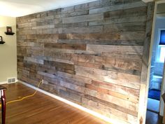 an empty room with wood paneling on the wall and hard wood floors in it