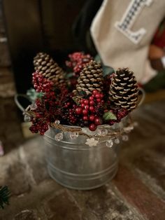 some pine cones and berries in a bucket