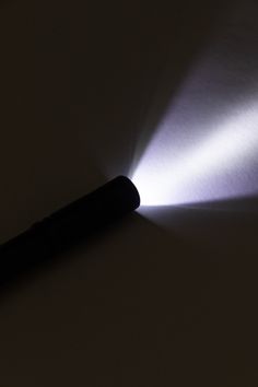 a flashlight is shining brightly on a dark surface with light coming from it's side