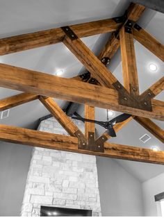 a large wooden beam in the middle of a room with a fireplace and ceiling fan