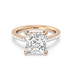 a yellow gold engagement ring with a princess cut diamond in the center and pave set shoulders