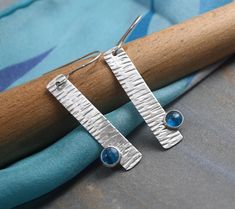 Modernist Earrings Modern, stylish and super light weight are these geometric themed earrings.  The elongated sterling silver rectangles have been hand stamped and have gemstones nestled into them.   The stones are natural 6mm neon blue apatite gems.  They're set in fine silver with solid silver backs. These earrings measure about 1/4" wide x 1-1/2" tall.  The total drop length from the very comfortable to wear 20 gauge sterling ear wires is about 2".   Made from 100% recycled fine and sterling silver in my Sarasota studio.   Finished to a bright sheen. Handmade by me in my Sarasota studio these arrive to you nicely gift boxed. For details on shipping, packaging and returns see shipping and policies tab above. Please visit my other shop to see more of my work: https://www.etsy.com/shop/Mar Modernist Earrings, Earrings Geometric, Blue Apatite, Neon Blue, Modern Earrings, Etsy Earrings Dangle, Sarasota, Fine Silver, Metal Jewelry