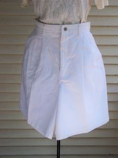 "Pleated-front trousers and shorts were popular during the 1980s. As you can see in the 2nd picture, both the trousers and shorts have 4 - 6 pleats in the front for a very loose and flowy fit. The waist is at the natural waist above the hips. The tight waistline and flowy shorts legs make the waist seem smaller. The looseness of the shorts covers any lumps and bumps. These shorts pair well with the flowy 1980s tops. Check those out in this store. These 1980s vintage shorts are made of Cotton Twi Classic High Waist Cotton Shorts, Pleated Short Length Bottoms For Daywear, Fitted Vintage Bottoms With Short Inseam, Short Pleated Cotton Bottoms, Cotton Pleated Short Bottoms, Vintage Fitted Shorts With Short Inseam, Classic Pleated High-waisted Shorts, Vintage Cotton Bermuda Bottoms, Vintage White Shorts