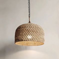 a woven light fixture hanging from a chain