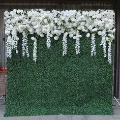 white flowers and greenery on display in front of a building