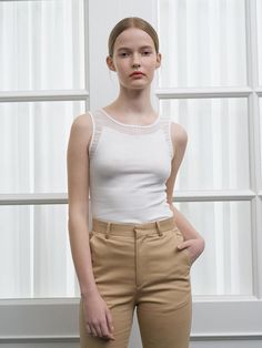 The Selena Sleeveless Top is a testament to timeless style with its classic tank silhouette and delicate neckline detailing. Tailored to skim the body, this top offers a balance of comfort and poise, making it a staple for any wardrobe. Its understated elegance is amplified by the soft, ribbed detailing along the trim, adding a hint of femininity to the piece. - The Selena Sleeveless Top features a ribbed neckline and armholes for a refined, textural touch.- Crafted to contour gracefully to the body, it ensures a flattering fit for a range of body types.- Its sleeveless design makes it a versatile layering option under blazers or cardigans, as well as a stand-alone piece in warmer weather.- The top's simplistic nature allows for endless styling possibilities, pairing seamlessly with b Chic Stretch Sleeveless Blouse Tank Top, Chic Stretch Sleeveless Tank Top, Chic Seamless Stretch Tank Top, Chic Stretch Mesh Tank Top, Feminine Stretch Sleeveless Tank Top, Feminine Fitted Sleeveless Tank Top, Fitted Feminine Tank Top, Elegant Stretch Tank Top For Spring, Spring Fitted Tank Top