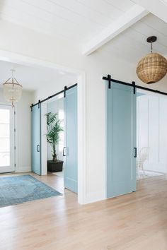 an empty room with blue doors and wooden floors