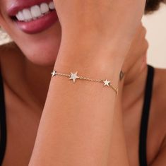 Ilse This dazzling bracelet features a celestial dreamscape, meticulously crafted in 14k solid gold (available in yellow, rose, or white gold). Dainty diamond star charms shimmer along a fine chain, creating a constellation of brilliance around your wrist. Each charm features a unique star design, intricately crafted to shimmer from every angle. - Handmade- Solid Gold- Natural Diamonds - G Color, SI Quality Diamonds- Dimensions of the Stars: 6 mm and 9 mm- Total Diamond Carat Weight: 0.10 ctw- D Handmade Fine Jewelry, Diamond Star, Dainty Bracelets, Diamond Bracelets, Bracelet Crafts, Gold Set, Colorful Bracelets, Quality Diamonds, Star Charms