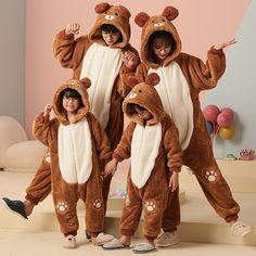 three children in animal onesuits posing for the camera