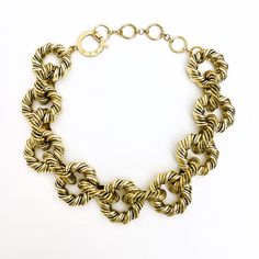 An elegant display of twisted metal links in gold color Hip Hop style. Modern Metal Jewelry With Chunky Chain, Chic Gold-tone Necklace With Lobster Clasp, Modern Chunky Chain Link Jewelry, Chic Metal Long Necklace With Chain, Chic Metal Chain Necklace, Chunky Adjustable Metal Jewelry, Elegant Metal Choker, Chic Long Metal Chain Necklace, Chic Metal Chain Necklace With Lobster Clasp