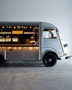 an ice cream truck with lights on the side is parked in front of a white wall