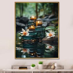 three lit candles sitting on top of a table in front of a wall with flowers