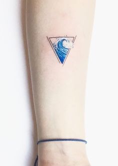 a woman's arm with a small blue wave tattoo on the left side of her body