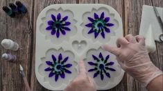 a person is working on an art project with purple flowers in the shape of hearts