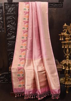 The Baby Pink Banarasi Katan Silk Saree is a delicate blend of elegance and artistry, showcasing intricate brocade work that enhances its soft, pastel hue. The exquisite meenakari border adds a vibrant touch, featuring rich colors and detailed patterns that beautifully complement the saree. Crafted from luxurious silk, it drapes gracefully, making it a perfect choice for festive occasions and celebrations, where it embodies timeless charm and sophistication. SILK MARK CERTIFIED This saree is ready to wear with fall and pico done. Handmade silk tassels adorn the pallu and add more grace to it. An unstitched blouse fabric is included. *Note: There may be minor variations in the shade, the texture of the product. Hues/textures show differently due to variations in screen settings and other fa Luxury Pink Banarasi Silk Salwar Kameez, Luxury Katan Silk Pre-draped Saree With Resham Embroidery, Luxury Katan Silk Unstitched Blouse, Luxury Katan Silk Fabric For Saree, Banarasi Katan Silk Saree, Silk Tassels, Katan Silk Saree, Katan Silk, Pastel Hues