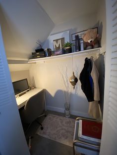 a small room with a desk, chair and computer