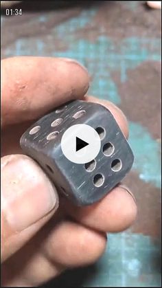 a hand holding a dice with holes in it