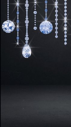 a black background with blue and white jewels hanging from it's sides