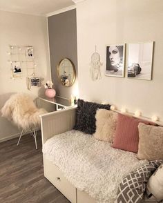 a living room with white furniture and pictures on the wall