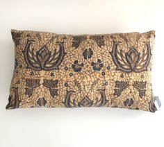 a brown and blue decorative pillow on a white wall