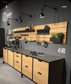 an industrial kitchen with wooden cabinets and hanging lights on the wall, along with potted plants