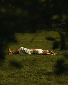 a man laying in the grass with his head on his back and arms behind him