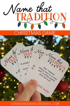 hand holding three christmas cards with the words name that tradition written on them in front of a christmas tree