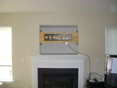 a living room with a fire place and television on top of the fireplace mantel