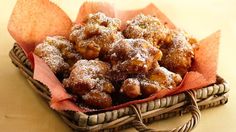 a basket filled with pastries covered in powdered sugar