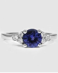 a blue sapphire and diamond ring on a white background