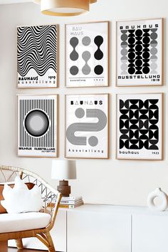 four black and white art prints hang on the wall above a chair in a living room