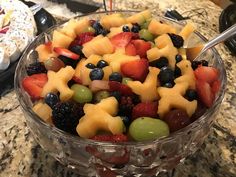 a glass bowl filled with lots of different types of fruit on top of a counter