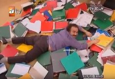 a man laying on the ground surrounded by lots of boxes and papers with his feet up