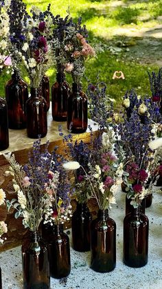 several brown vases filled with different types of flowers